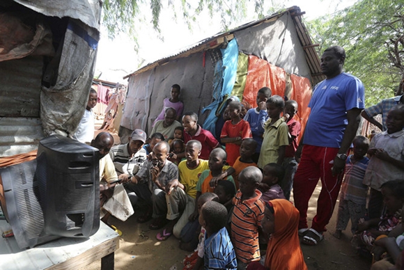 Internally displaced Somali people crowd around a television set to watch the World Cup in Brazil highlights, in the capital Mogadishu