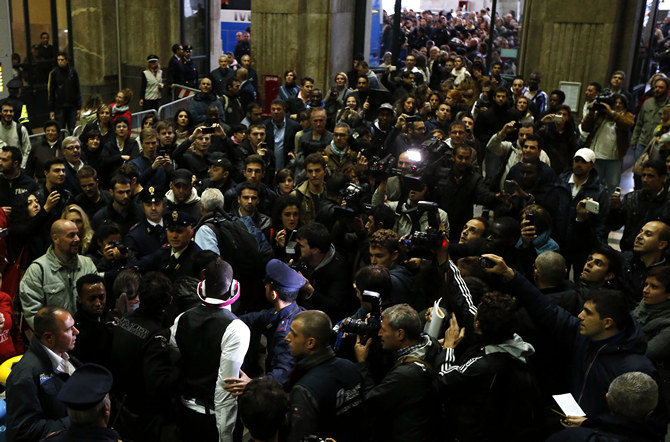 Italy's Mario Balotelli is escorted as he arrives with the national soccer team at the Railway Central station in Milan