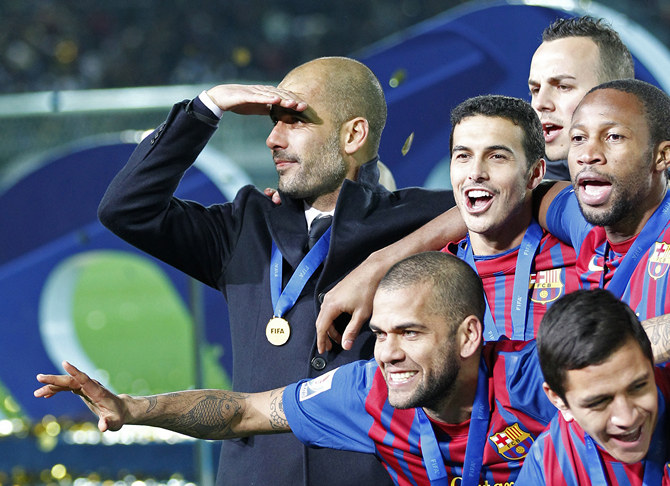 Coach Guardiola of Spain's Barcelona celebrates with players on the podium after their win in the Club World Cup final soccer match against Brazil's Santos in Yokohama