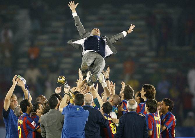 Members of Barcelona's soccer team throw coach Pep Guardiola in the air after defeating Estudiantes in their FIFA Club World Cup final in Abu Dhabi