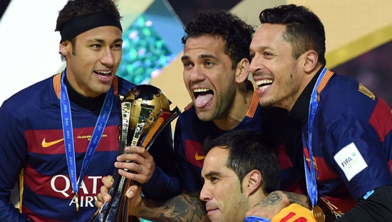 Barcelona players, Neymar (L), Dani Alves (C), Adriano (R) and Claudio Bravo (yellow) smile as they hold the FIFA Club World Cup trophy at the Club World Cup final in Yokohama, suburban Tokyo on December 20, 2015.    AFP PHOTO / TOSHIFUMI KITAMURA / AFP / TOSHIFUMI KITAMURA        (Photo credit should read TOSHIFUMI KITAMURA/AFP/Getty Images)